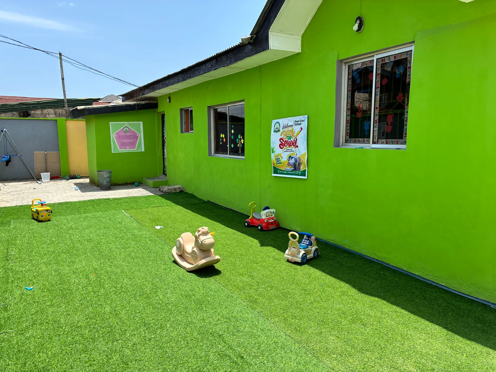 Ride-on toys on the play lawn beside the nursery classrooms